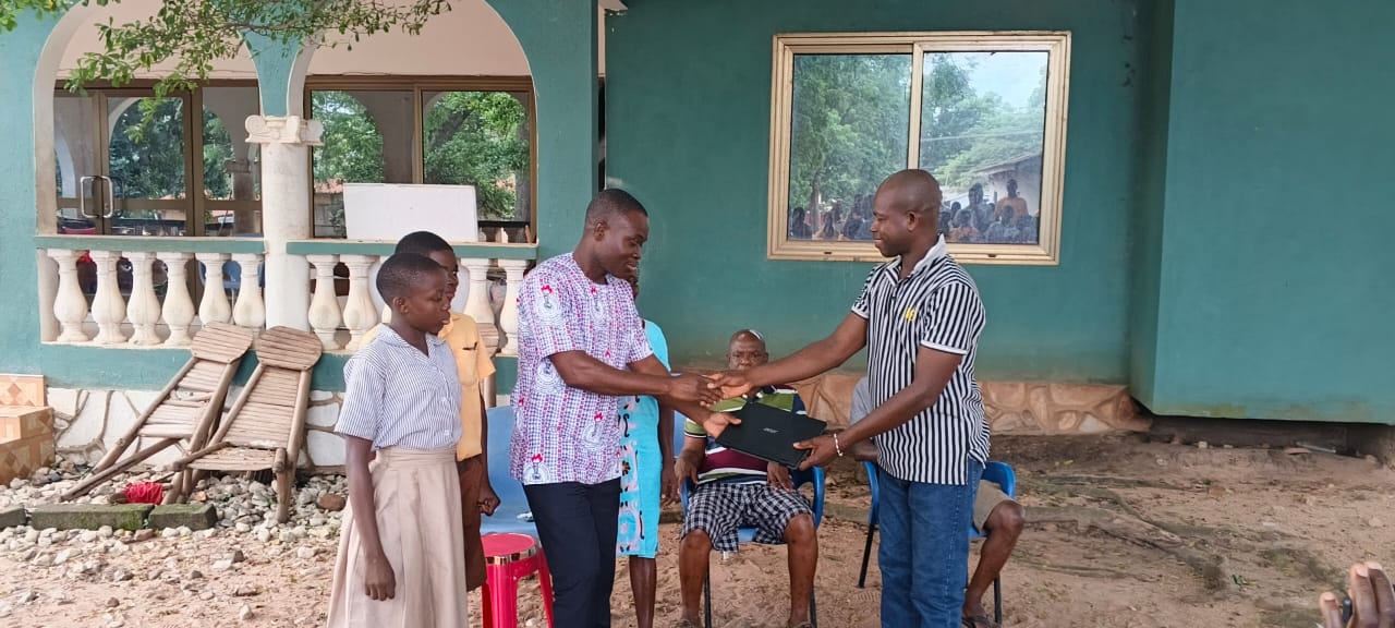 Togbe Dzegblade presents laptop computers to Adaklu Kodzobi Basic School 