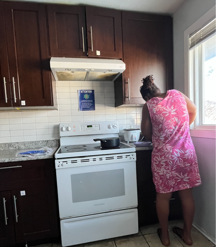 A kitchen with an electric stove that does not cause emissions, and an extractor hood to remove any smoke that comes from cooking.